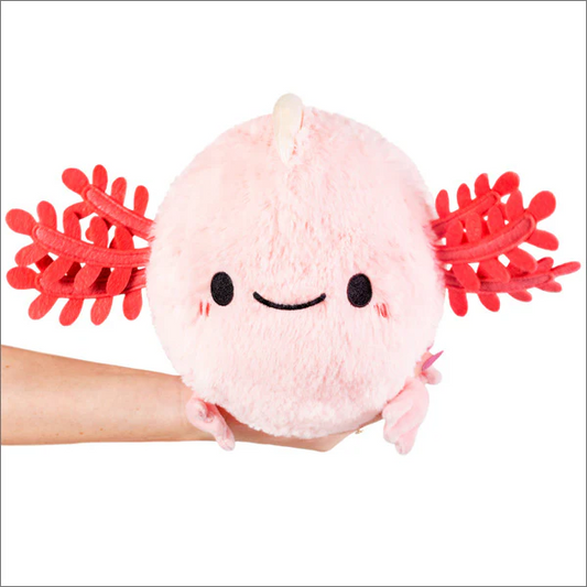 Mini Squishable Baby Axolotl, a round pink plush toy, held in a hand against a white background.