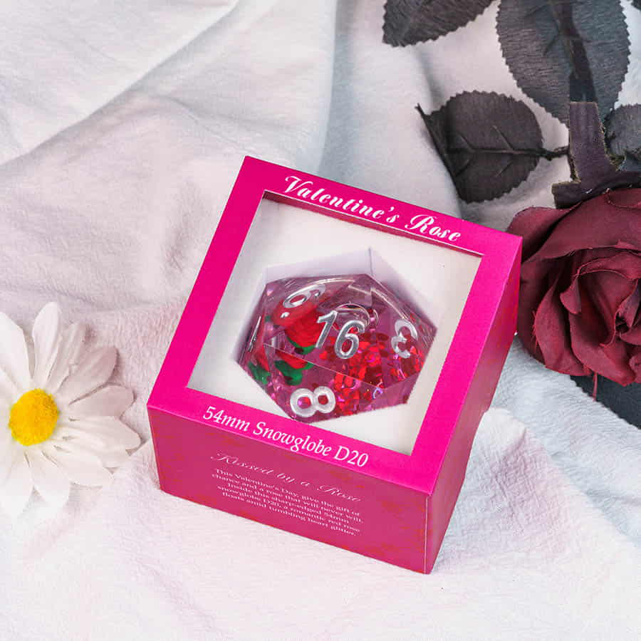 Large D20 Snowglobe: Valentines Rose edition, clear die with red and green inside, in a pink labeled box.