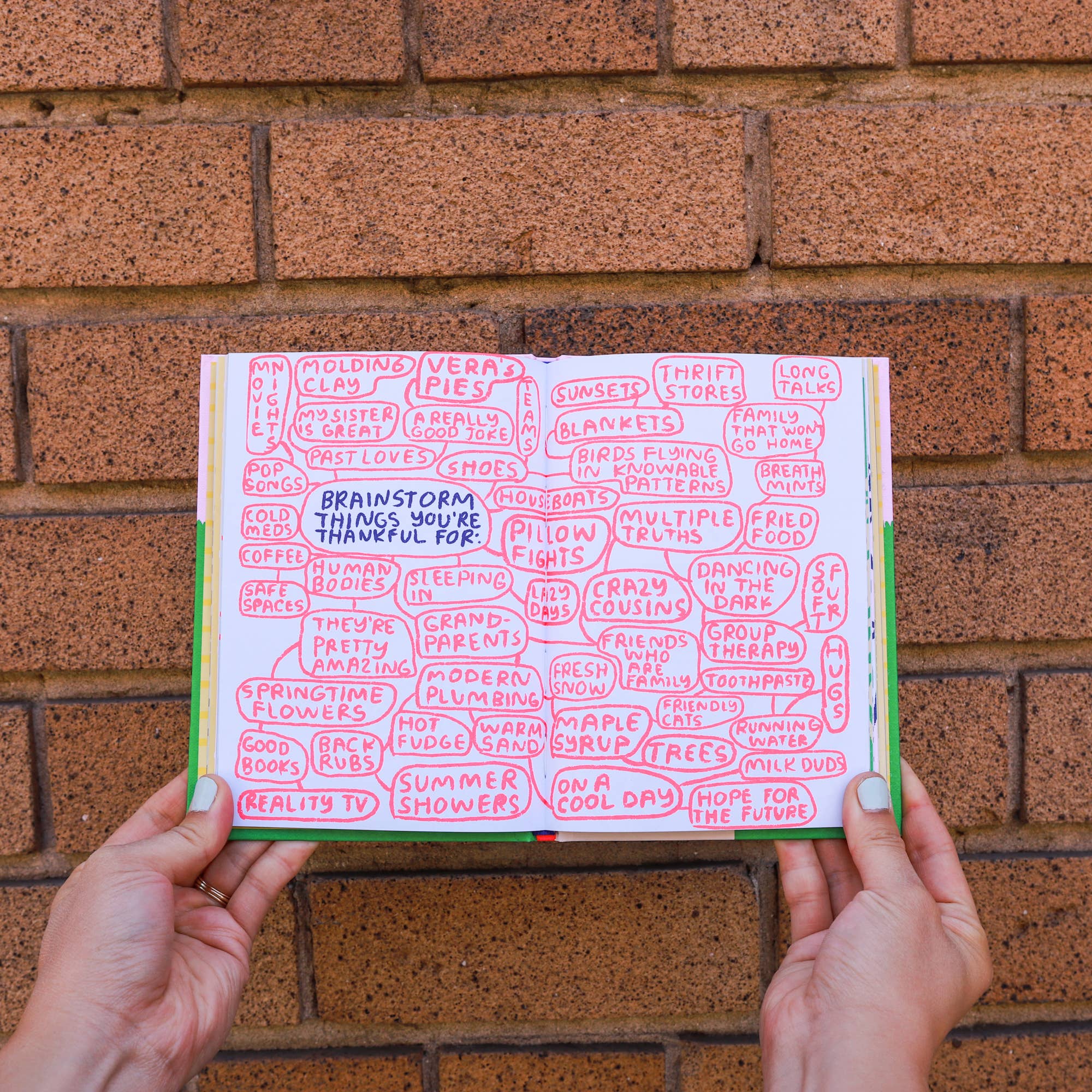 Person holding a book titled Its OK to Feel Things Deeply, focused on self-love and thankfulness.