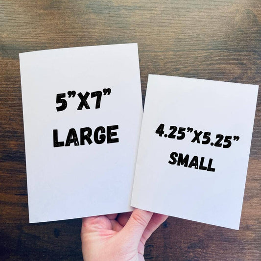 Two Mothman Cryptid Funny Birthday Cards, one large 5x7 and one small 4.25x5.25, displayed on a wooden surface.
