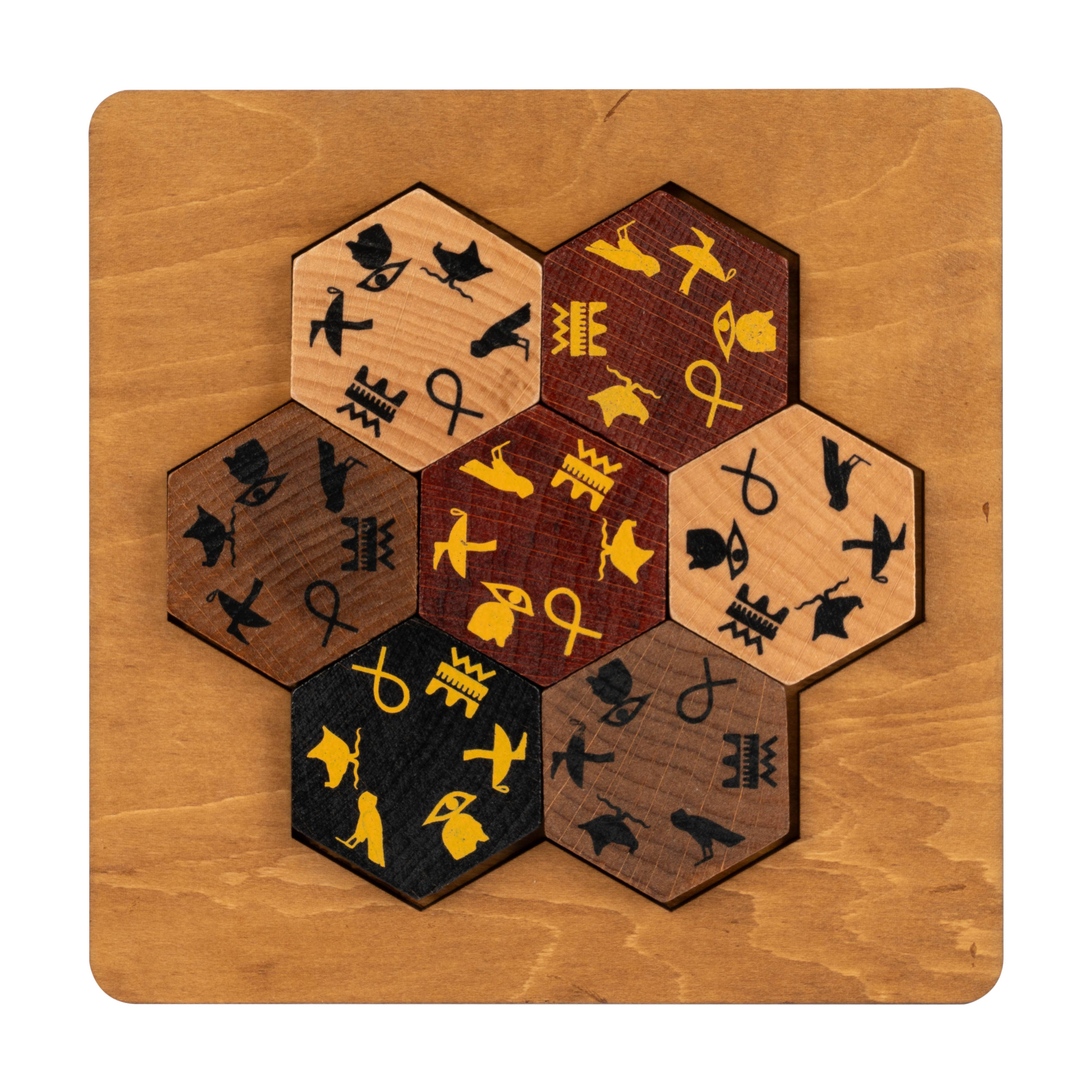 Seven hexagonal Egyptian Hieroglyph Puzzle tiles arranged in a flower pattern on a wooden board.