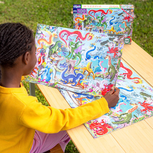 Love of Dragons 100 Piece Puzzle being assembled on a wooden table outdoors.