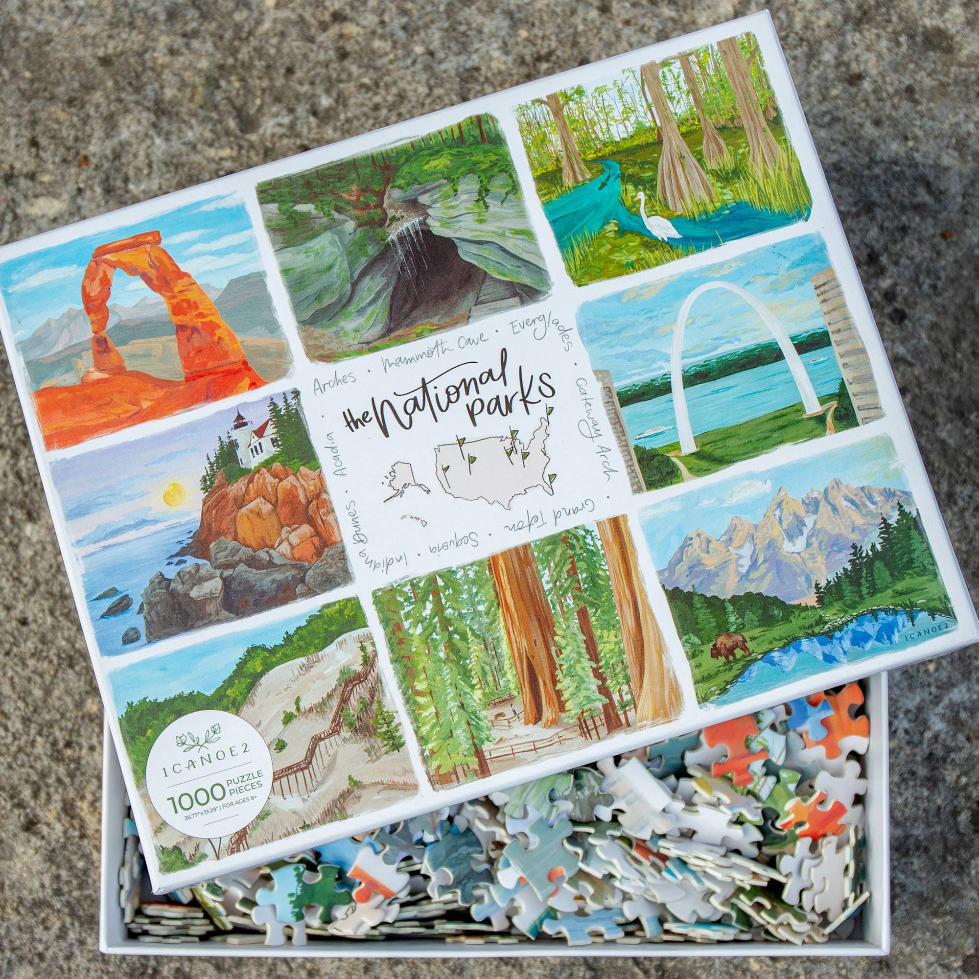 The National Parks 1,000 piece jigsaw puzzle with hand-painted scenes and loose pieces in an open box.
