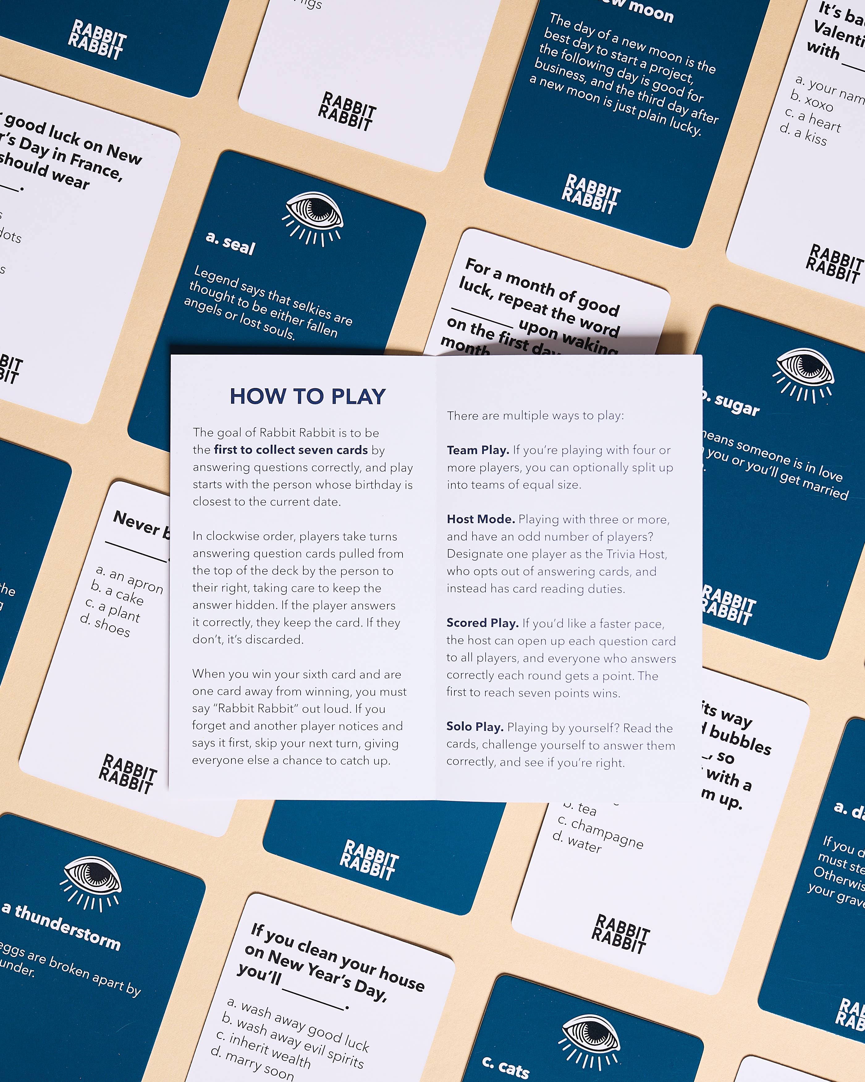 Rabbit Rabbit: A Game of Superstitions cards with How to Play card displayed in the center.