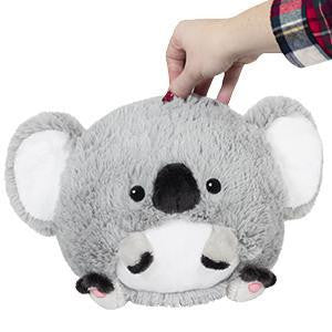 Hand holding Baby Koala 7 Squishable plush with big ears and a white belly.