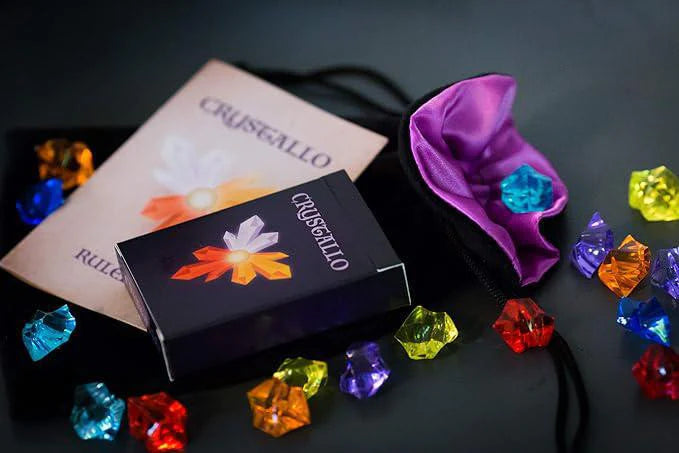 Crystallo game components: plastic crystals, purple pouch, and game rules.