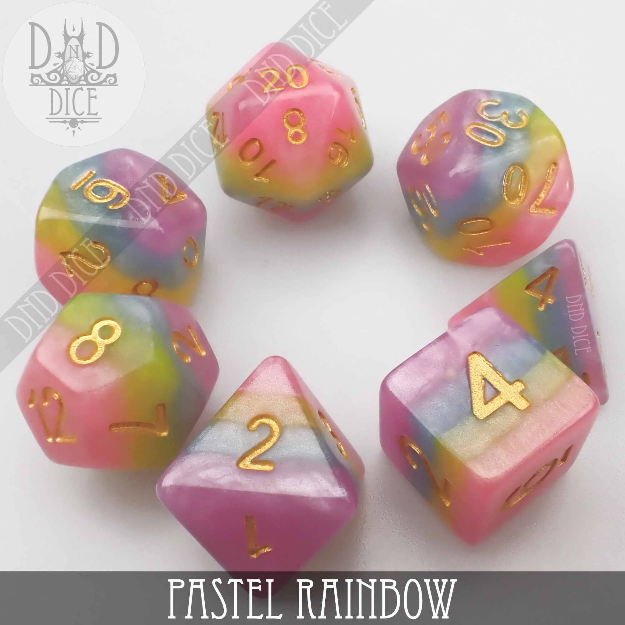 Pastel rainbow resin DnD dice set with gold numbers on a white background.