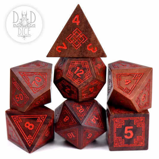 7-piece red/brown Guibourtia wood dice set with intricate patterns in a pyramid-shaped gift box.