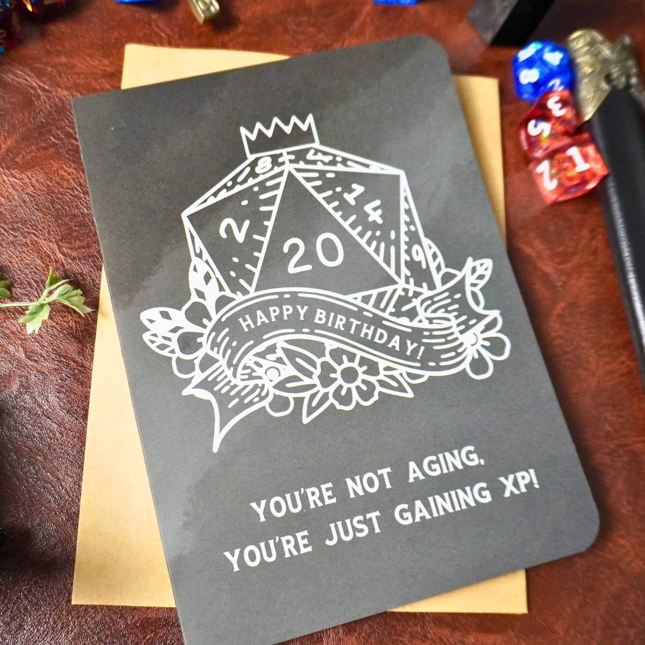 Youre Not Aging XP DnD Birthday Card with a D20, flowers, and the text YOURE JUST GAINING XP.