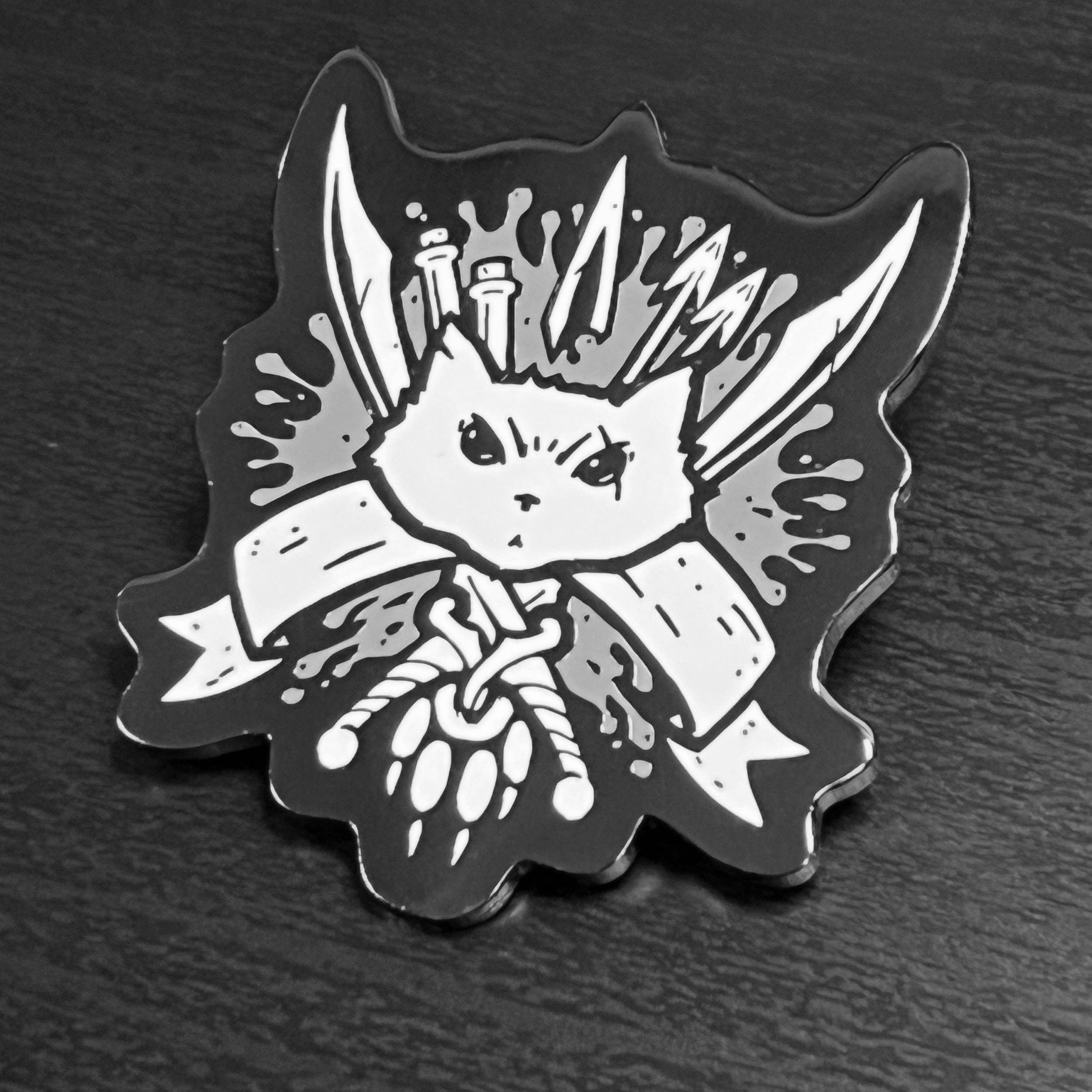 Blood Hunter Enamel Pin: black and white hard enamel pin of angry cat head with knives, pencils, and a banner.