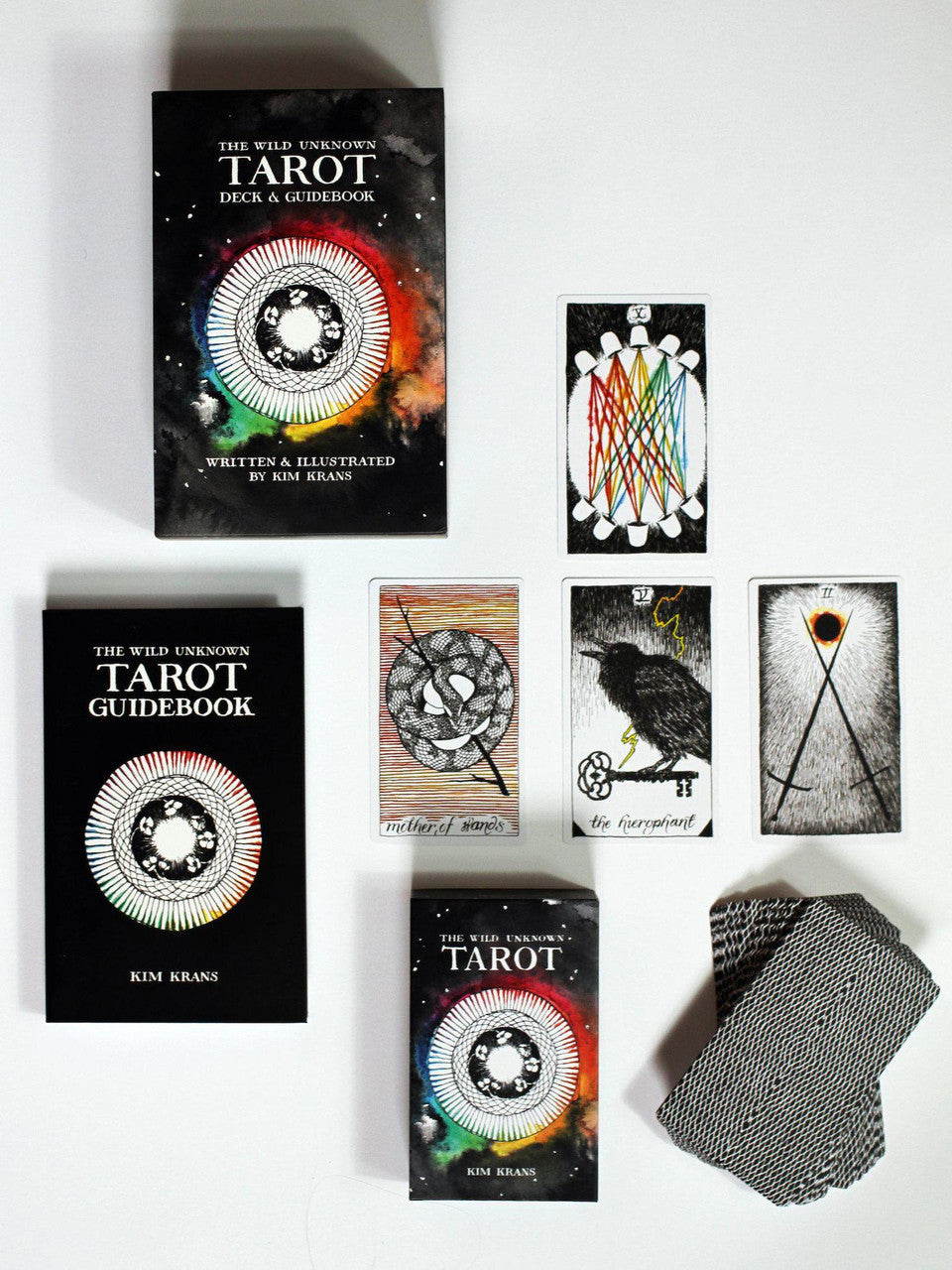 Wild Unknown Tarot Deck and Guidebook with five tarot cards shown on a white surface.