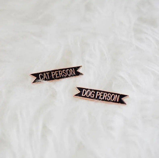 Cat Person enamel pin displayed on a white, fluffy surface.