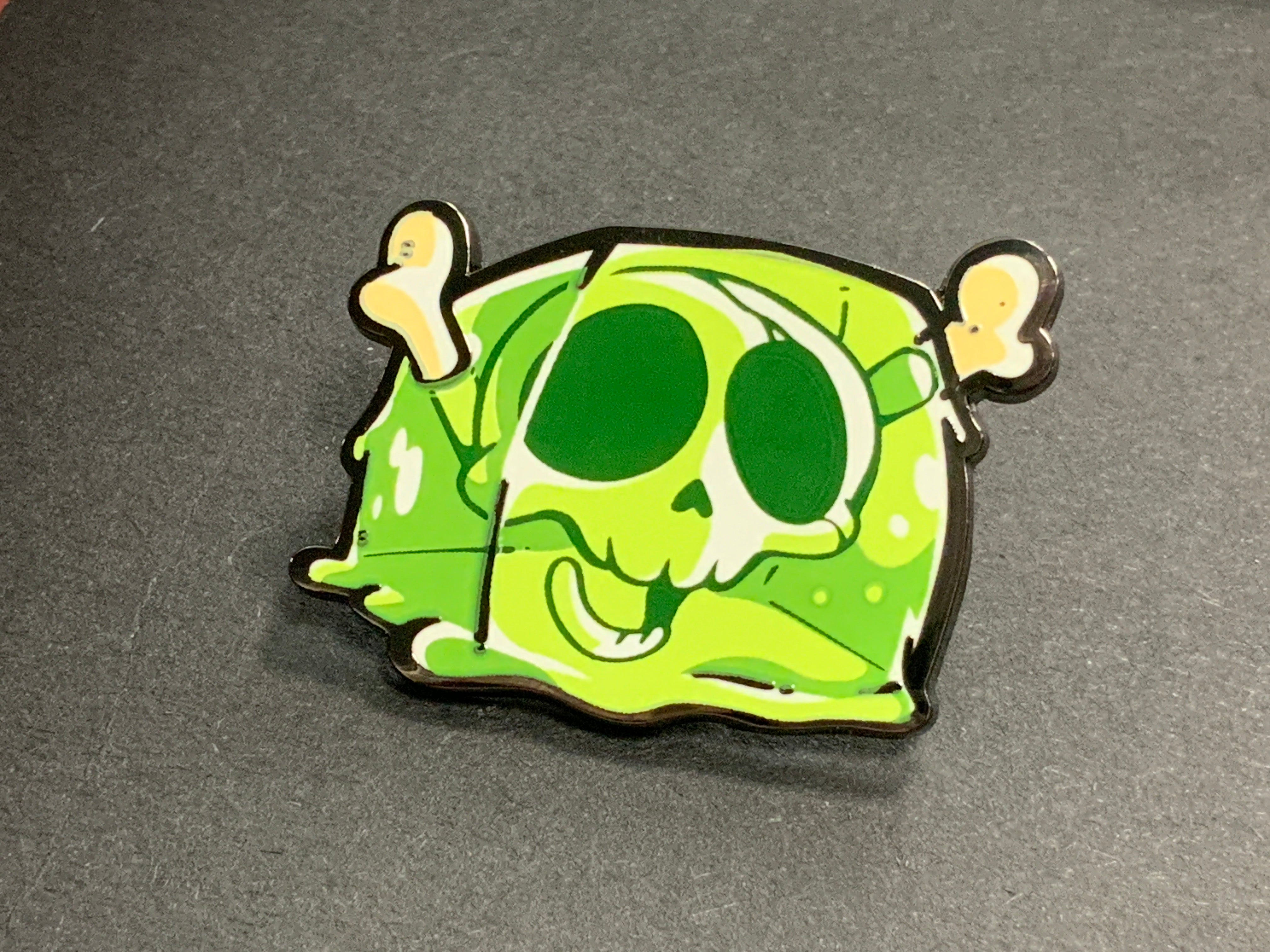 Heliana Monster Hunting Pin Gelatinooze featuring a green slime with skull and bones design.