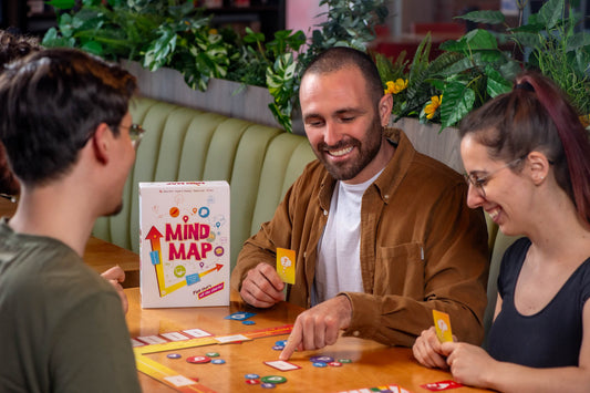 Mind Map strategy board game in use, shown with cards and tokens. Four people are playing.