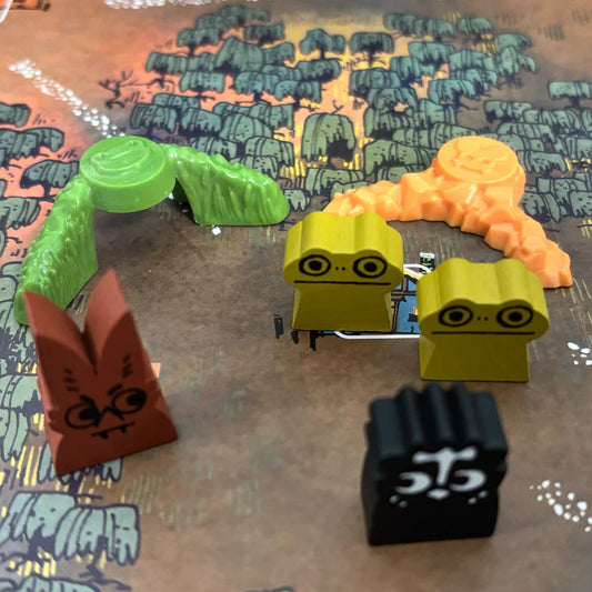 Root: Deluxe Frog Clearing Markers and colorful animal figures on a board with tree art.