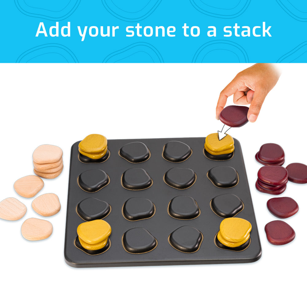 Hand placing maroon stone on Qawale board with stacked yellow, maroon, and beige stones.