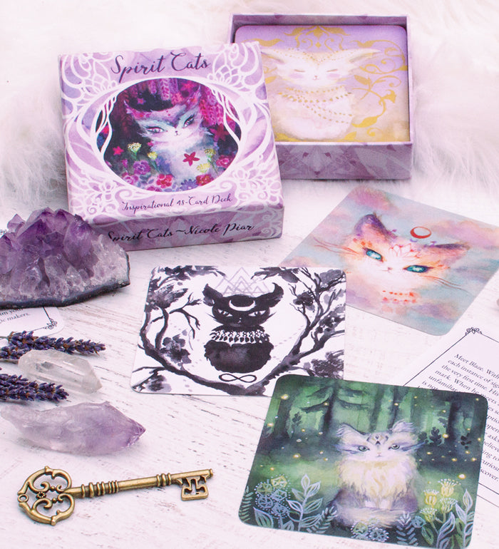 Spirit Cats Oracle Deck with crystals, key, lavender, and guidebook on a white background.