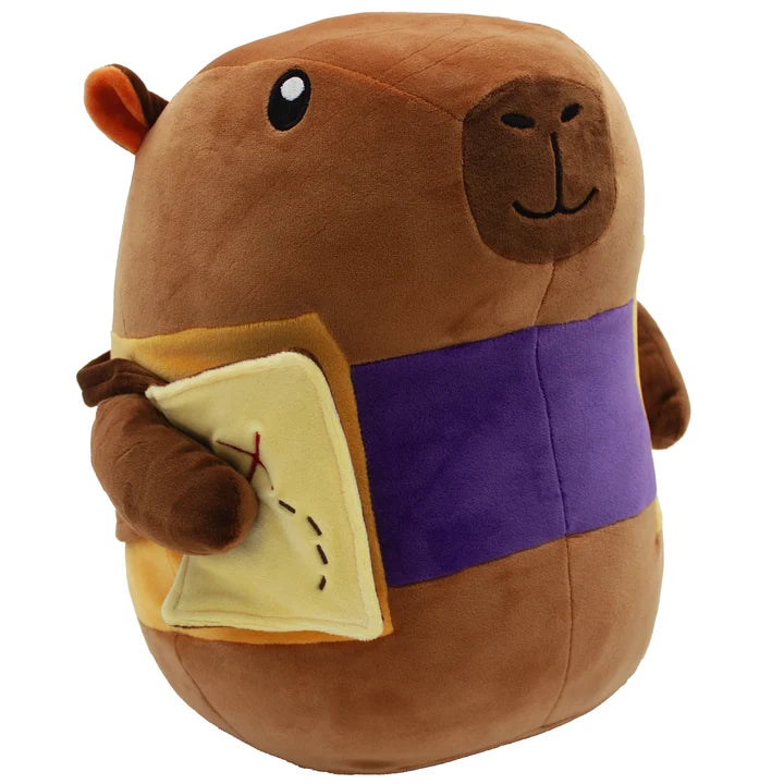 Cozy Critters Everdell Plush Coconut Capybara with a purple band and holding a yellow book.