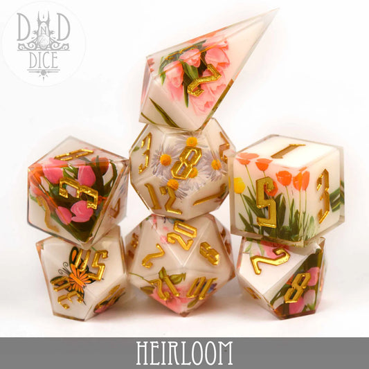 Heirloom (Handmade) 7-piece clear resin polyhedral dice set with gold numbers and embedded flowers.