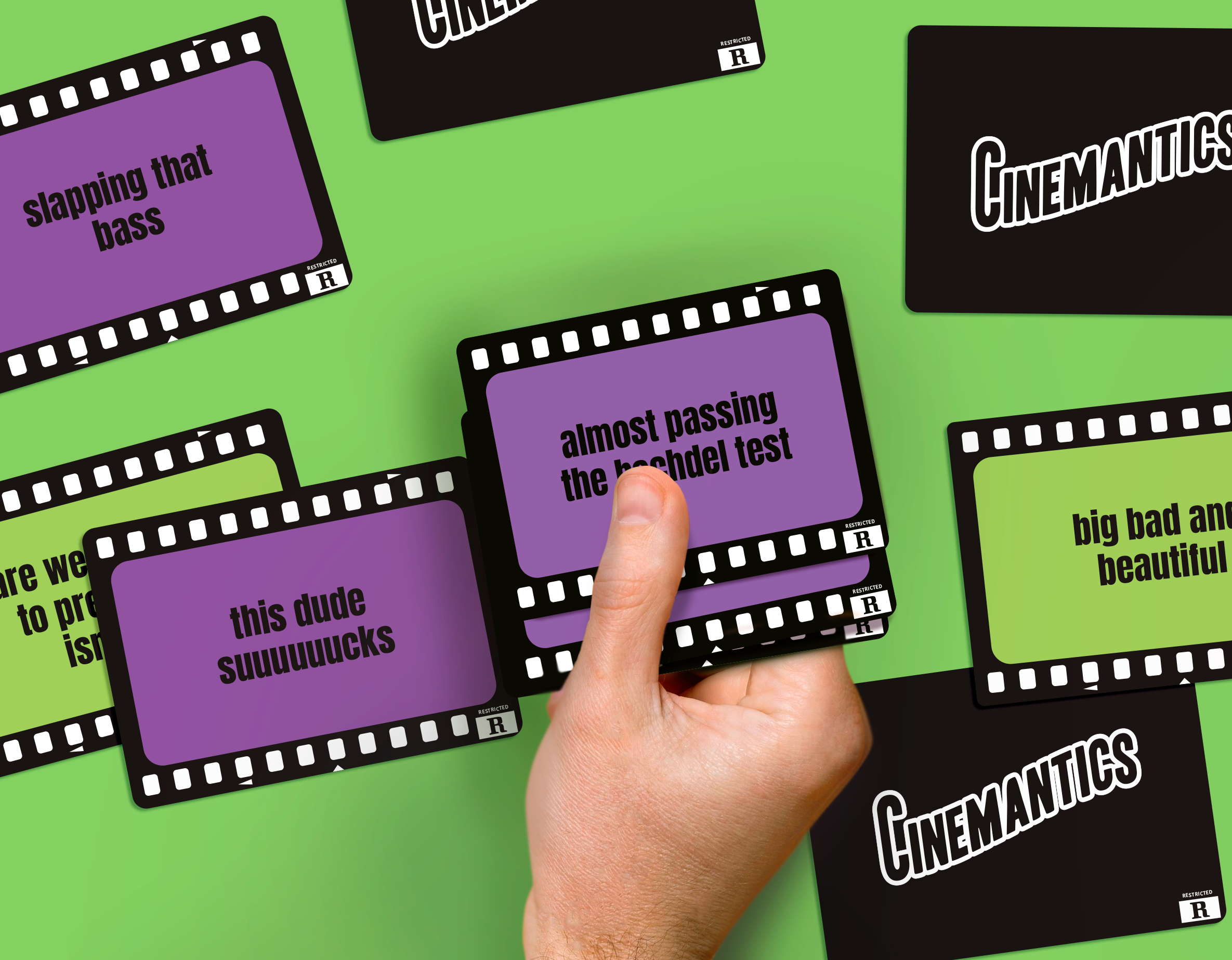 Cinemantics® card reading almost passing the bechdel test held in hand with other movie night cards on green background.