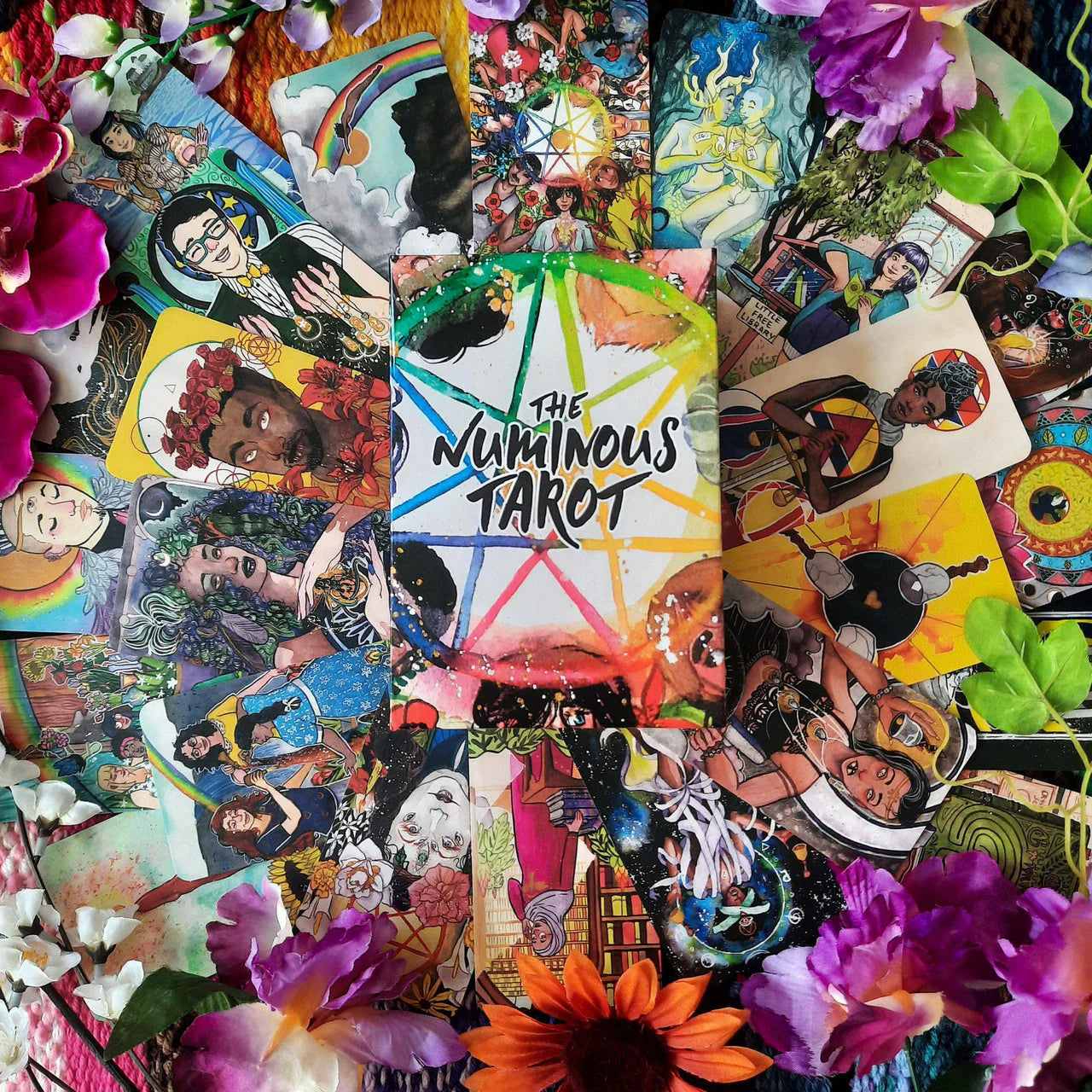 The Numinous Tarot by Cedar McCloud arranged in a circle, surrounded by flowers and decorative accents.