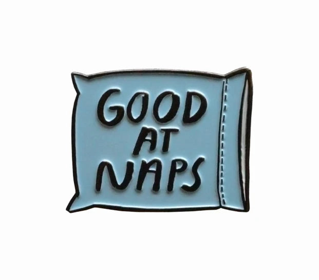 Good At Naps Pin with a blue pillow illustration and bold black text.