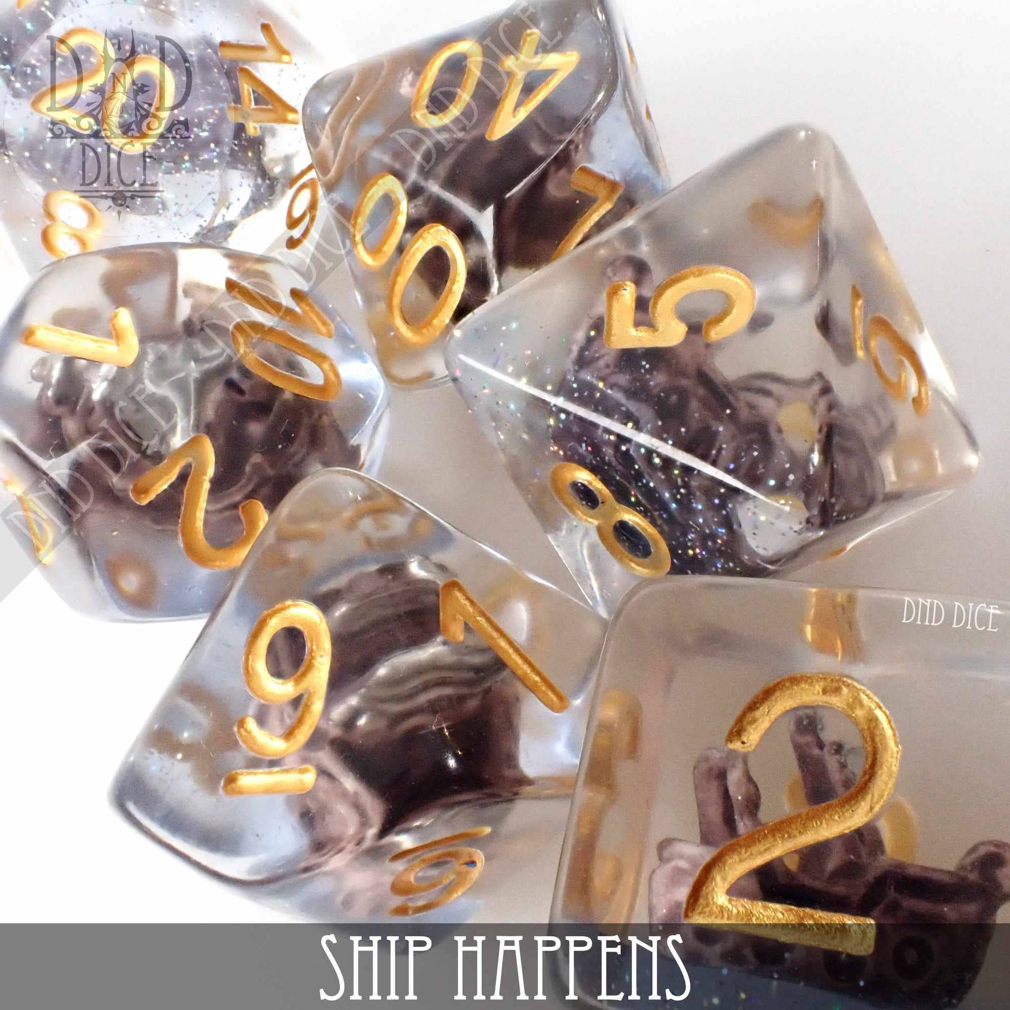 Ship Happens 7-piece clear resin dice set with gold numbers and miniature ship models inside each die.