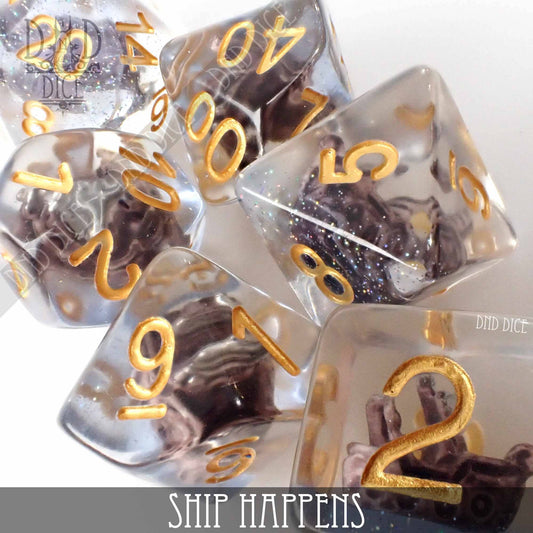 Ship Happens 7-piece clear resin dice set with gold numbers and miniature ship models inside each die.