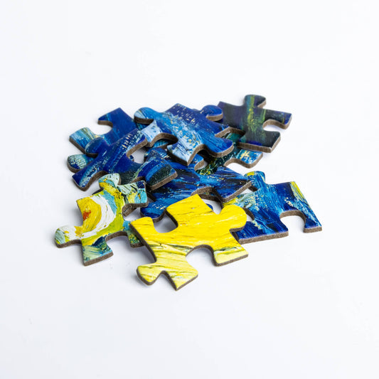Puzzle - Vincent van Gogh - Starry Night pieces with blue and yellow patterns on a white background.