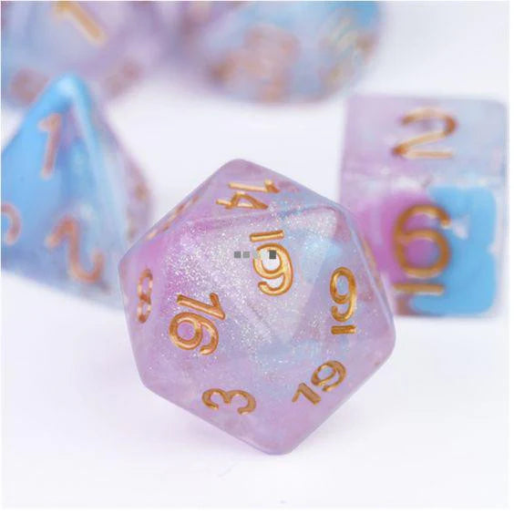 Flare of Ambition RPG dice set with a pastel glitter d20 with gold numbers and assorted colorful polyhedral dice.