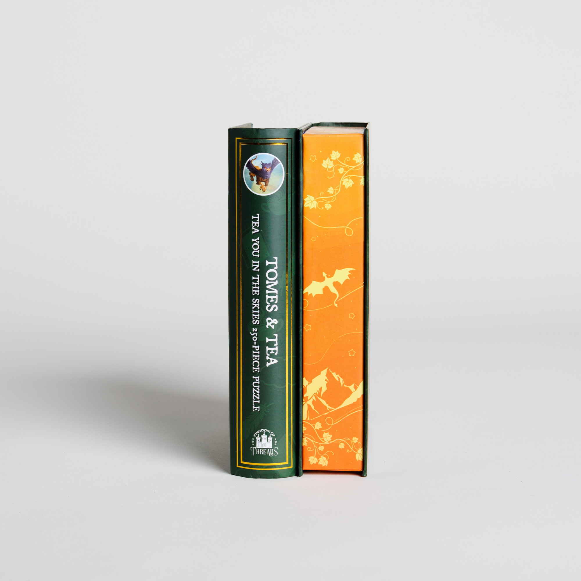Tomes & Tea Tea You in the Skies green puzzle box and an orange animal-themed puzzle box.