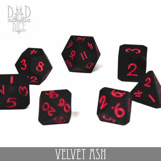 Velvet Ash 7-piece black silicone polyhedral dice set with red numbers.