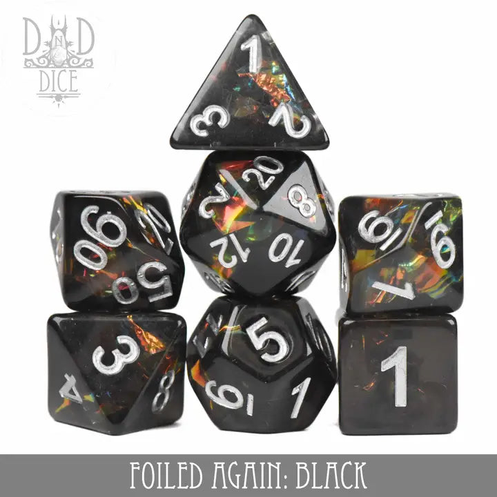 Foiled Again Black 7-piece polyhedral black resin dice set with silver numbers and multicolored foil accents inside.