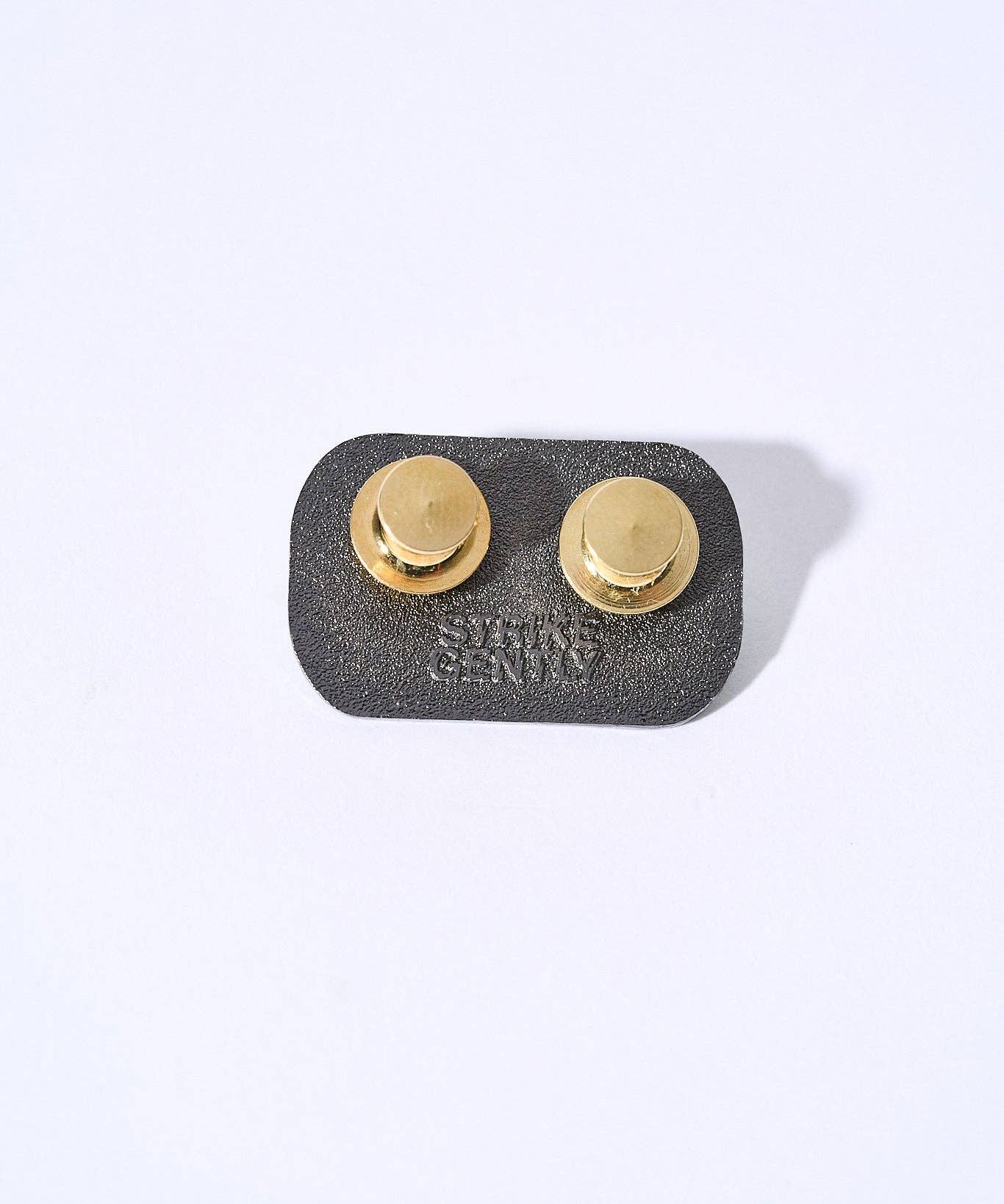 Back of a 1.25-inch Buy a man eat fish hard enamel pin featuring two gold-tone locking clasps and embossed brand text.
