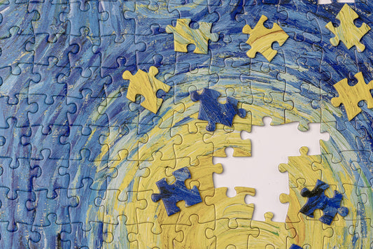 Partially assembled 1000-piece puzzle, Vincent van Gogh Starry Night, blue and yellow swirls visible.