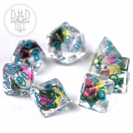 Vintage Bloom 7-piece D&D dice set with colorful flowers in clear resin and blue numbers on a white background.