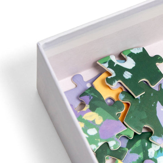 Twilight Garden 500 Piece Jigsaw Puzzle with green, yellow, and purple patterns in a white box on a white surface.