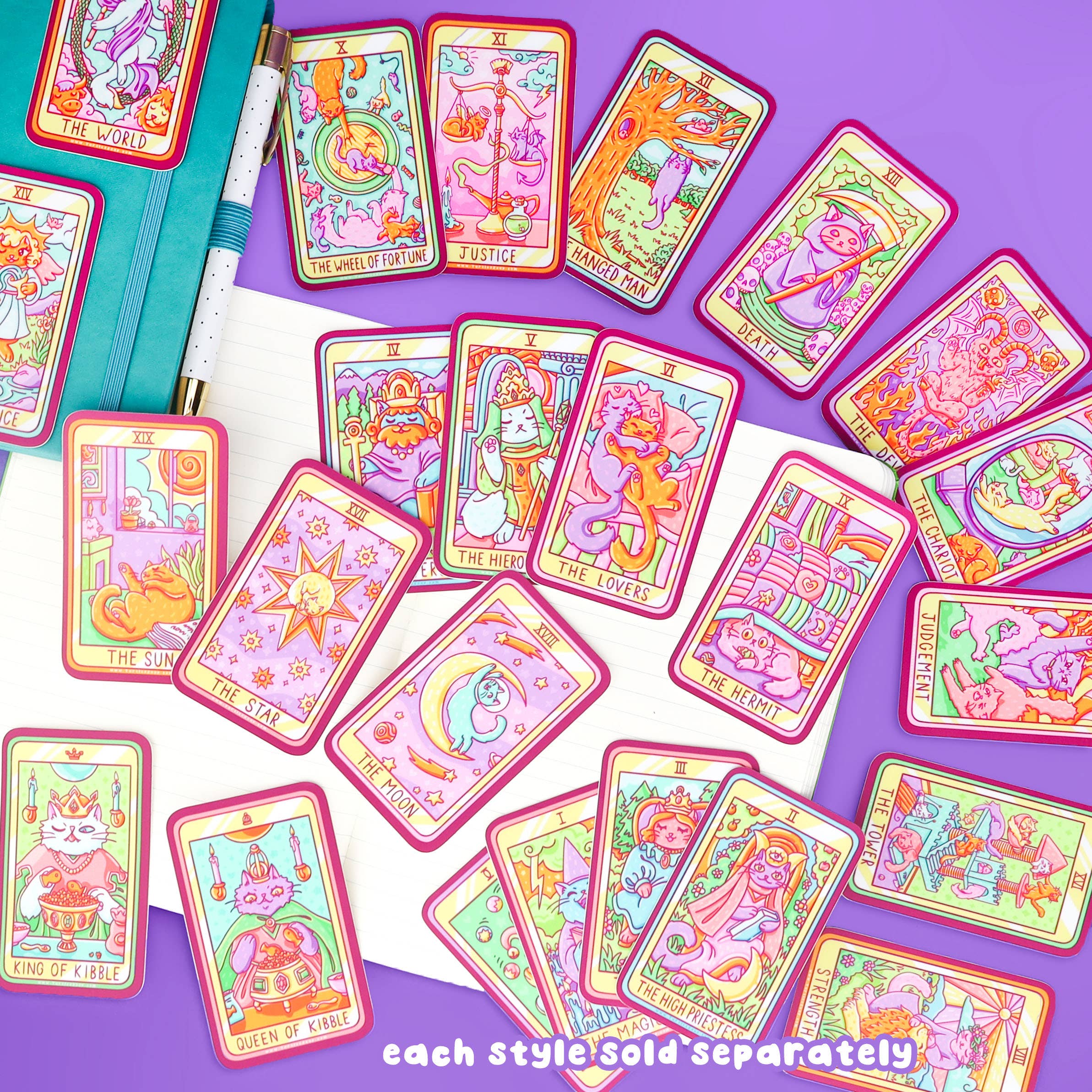 The Sun Cat Major Arcana Tarot Card Vinyl Sticker displayed on a purple surface next to stationery and tarot cards.