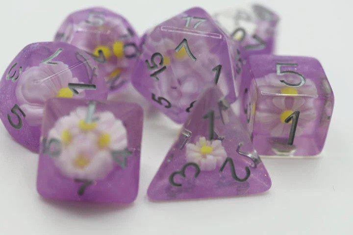 Lazy Daisy RPG Dice Set with purple polyhedral dice decorated with small white and yellow flowers.
