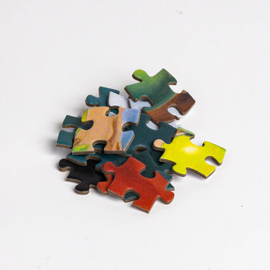 Puzzle - René Magritte - Son of Man pieces scattered on a white background.