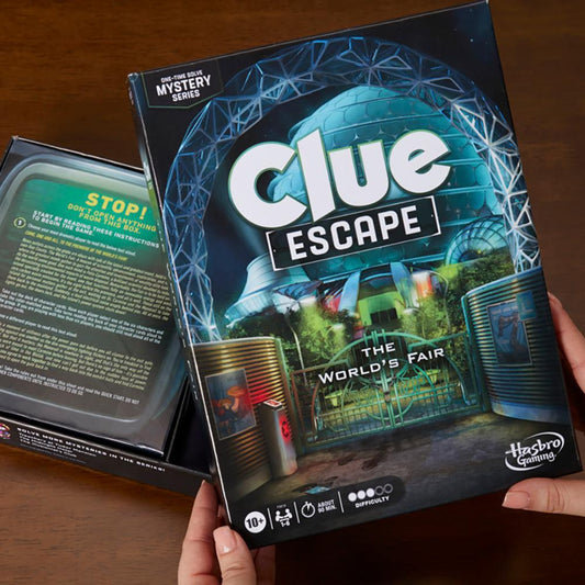 Clue Escape The Worlds Fair board game held in hands on a wooden table.