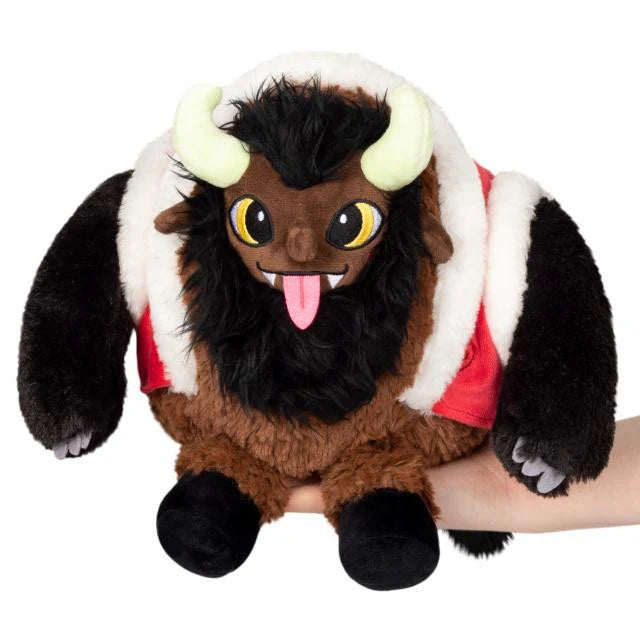 Mini Squishable Krampus plush with big eyes, horns, and tongue out, held in a hand.