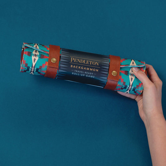 Pendleton Backgammon roll-up game with patterned fabric and leather straps held in a hand.
