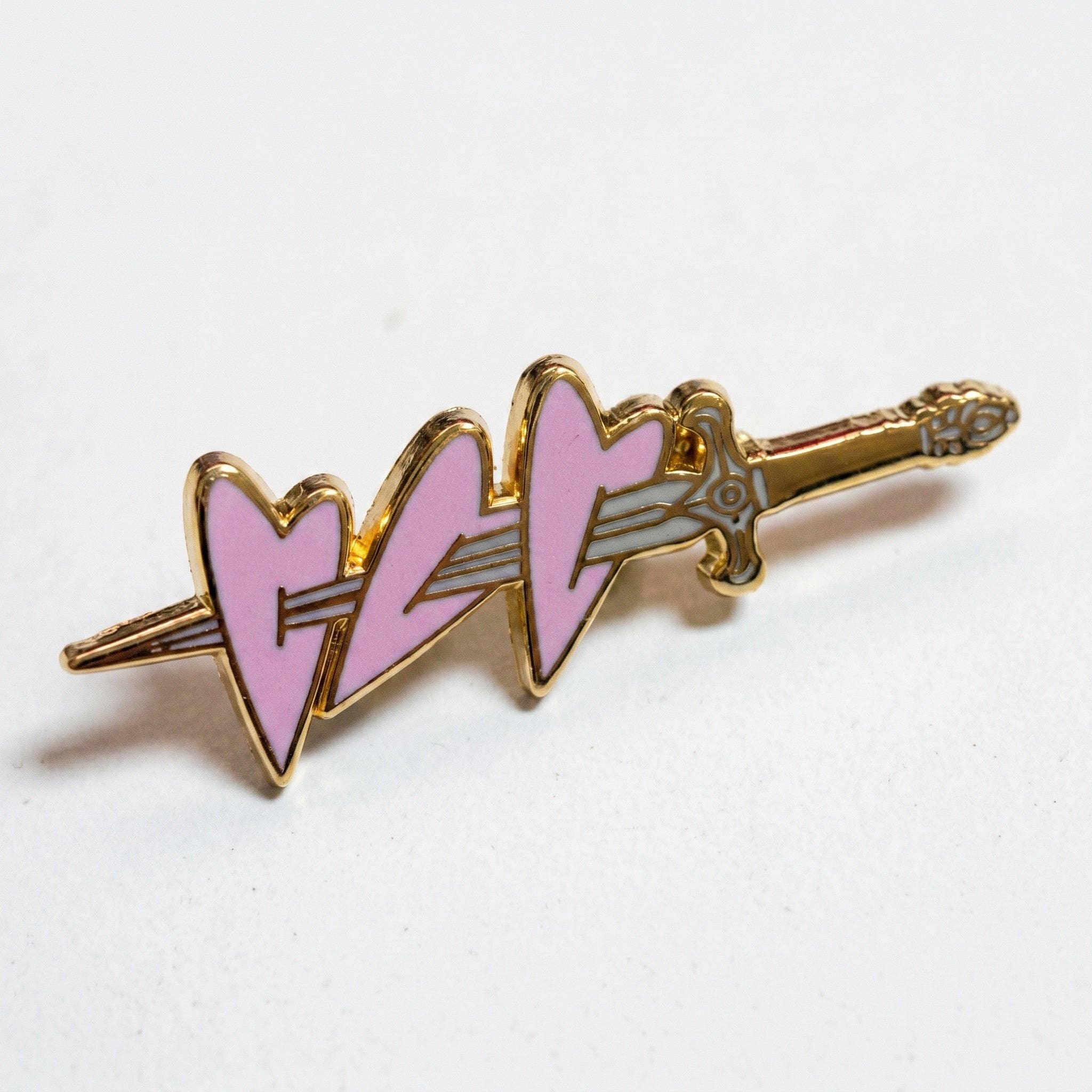 Pierced Hearts pin: gold-toned hard enamel pin featuring a sword piercing three pink hearts, with a deluxe clasp.