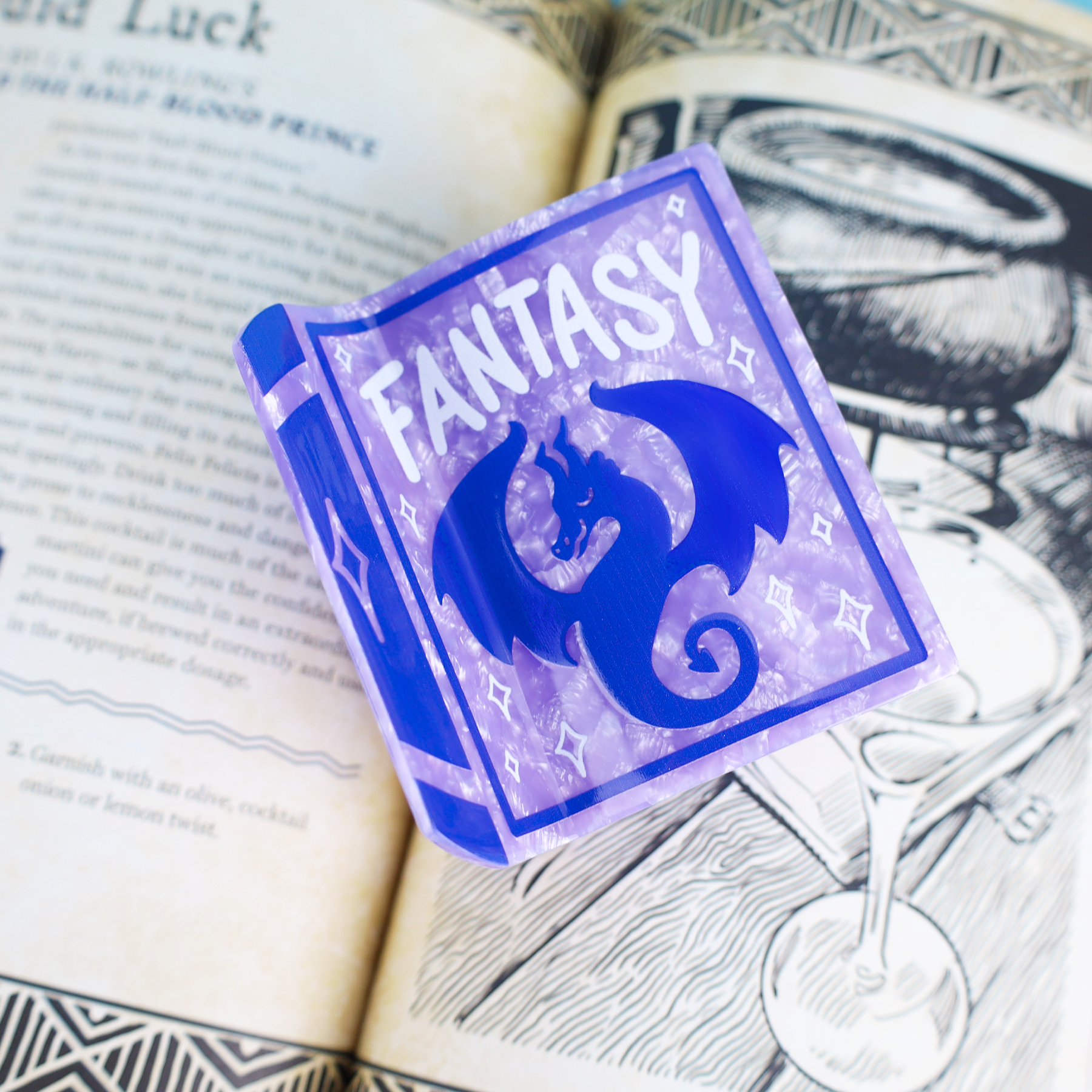 Purple Fantasy Book and dragon hair claw displayed on top of an open book.