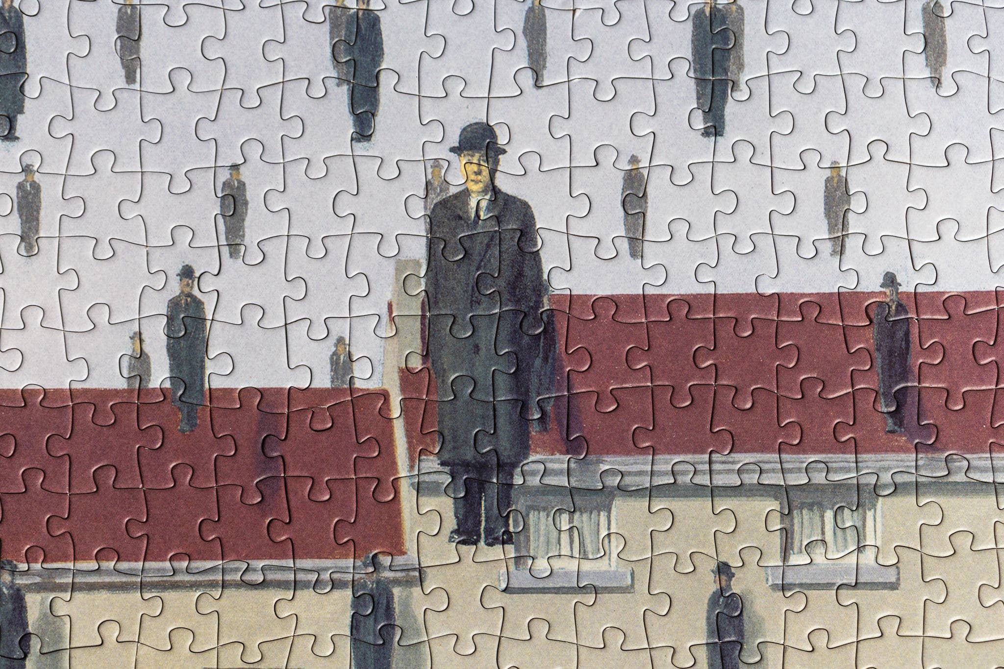 René Magritte Golconda 1000-piece puzzle featuring men in coats and hats on a red and gray background.