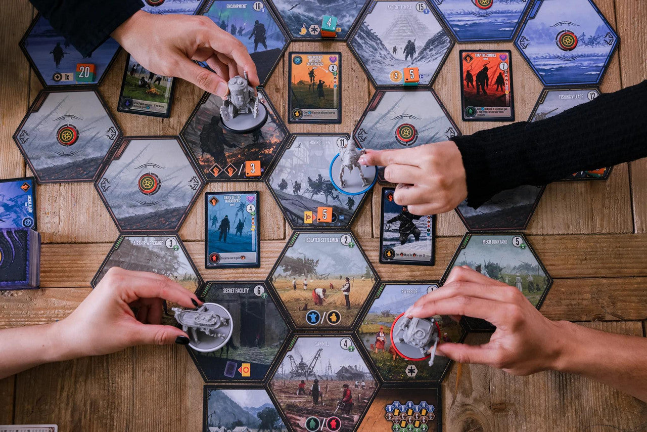 Scythe Expeditions Ironclad edition board game in play with three people moving pieces and cards on a hexagonal board.