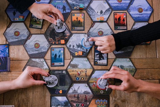 Scythe Expeditions Ironclad edition board game in play with three people moving pieces and cards on a hexagonal board.