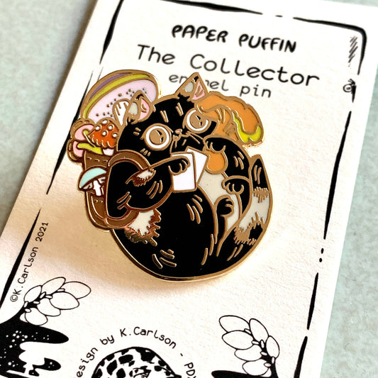 Collector Mushroom Cat enamel pin: a black cat with a mushroom-filled backpack holding a white paper.