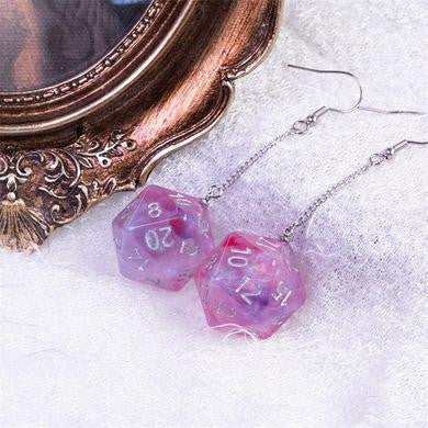 Two D20 Galaxy Earrings, one purple and one red, displayed on white fabric.